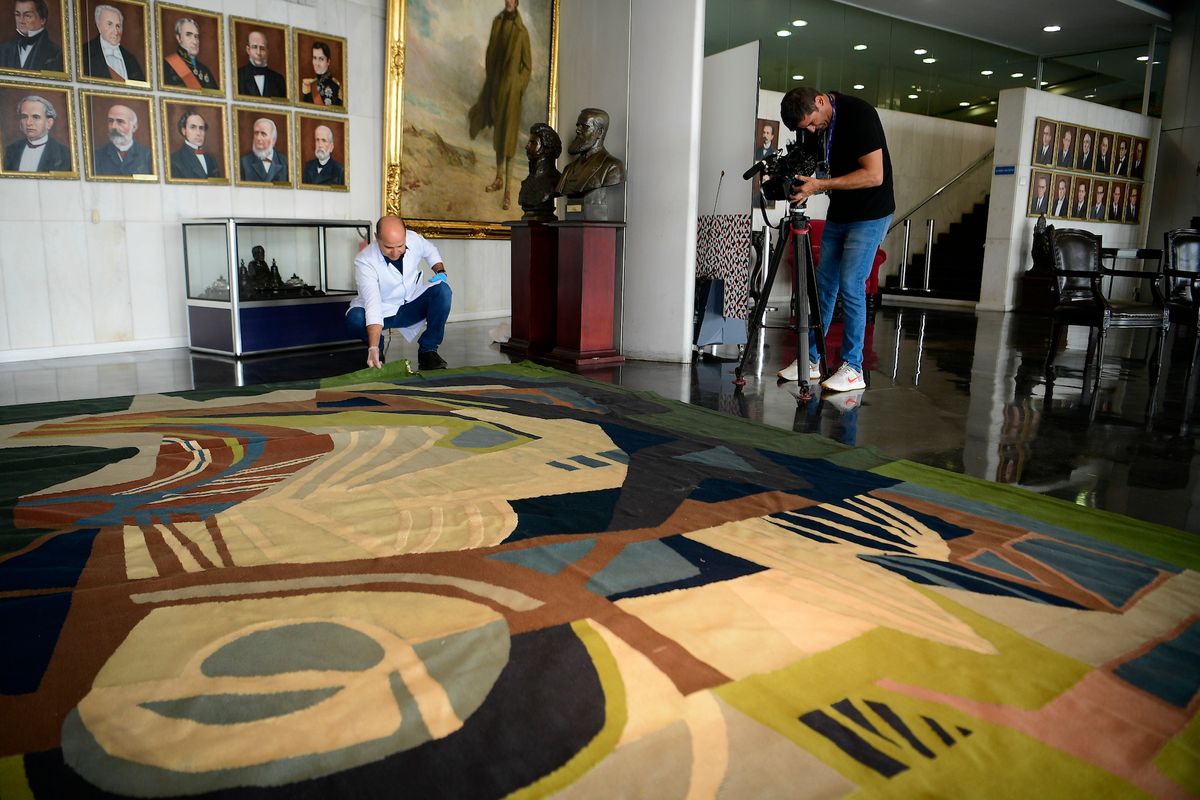 In 2023, a parliamentary assistant at the Serviço de Conservação e Preservação do Museu, Raimundo Nonato Nascimento Soares, shows the damage caused to Roberto Burle Marx's tapestry Photo by Pedro França/Agência Senado, via Wikimedia Commons