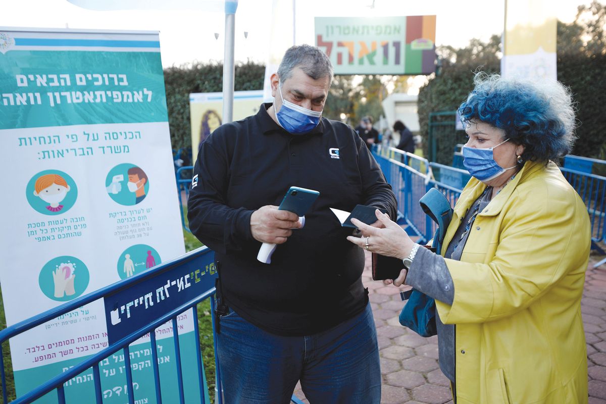 A woman showing her “green pass” as she enters singer Nurit Galron’s concert in Yarkon Park, Tel Aviv, in late February Amir Cohen/Reuters/Alamy