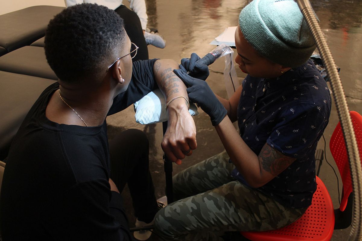 The artist Doreen Garner works on a tattoo at Recess as part of her project Invisible Man Tattoo Recess