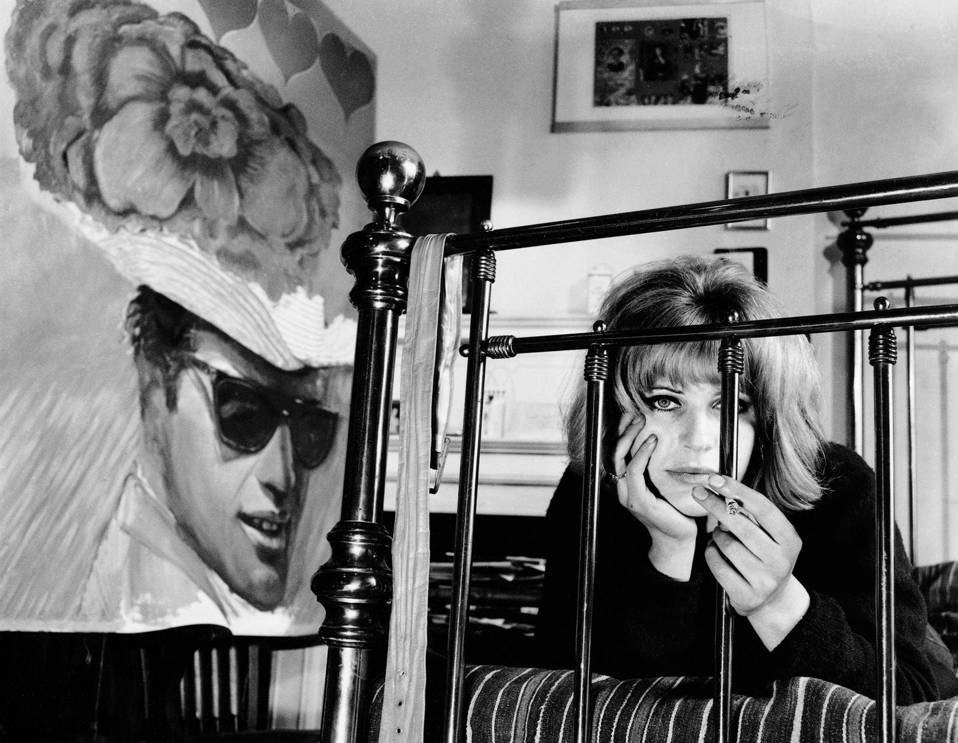 Pauline Boty in 1963 alongside her painting titled With Love to Jean-Paul Belmondo (1962) © The Lewinski Archive at Chatsworth/Bridgeman Images