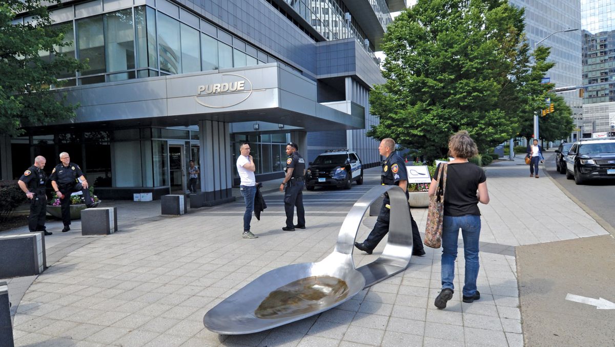 Domenic Esposito’s opium-spoon sculpture was placed outside Purdue Pharma’s offices by the gallery owner Fernando Luis Alvarez (in white shirt), who was later arrested for refusing to remove it Domenic Esposito