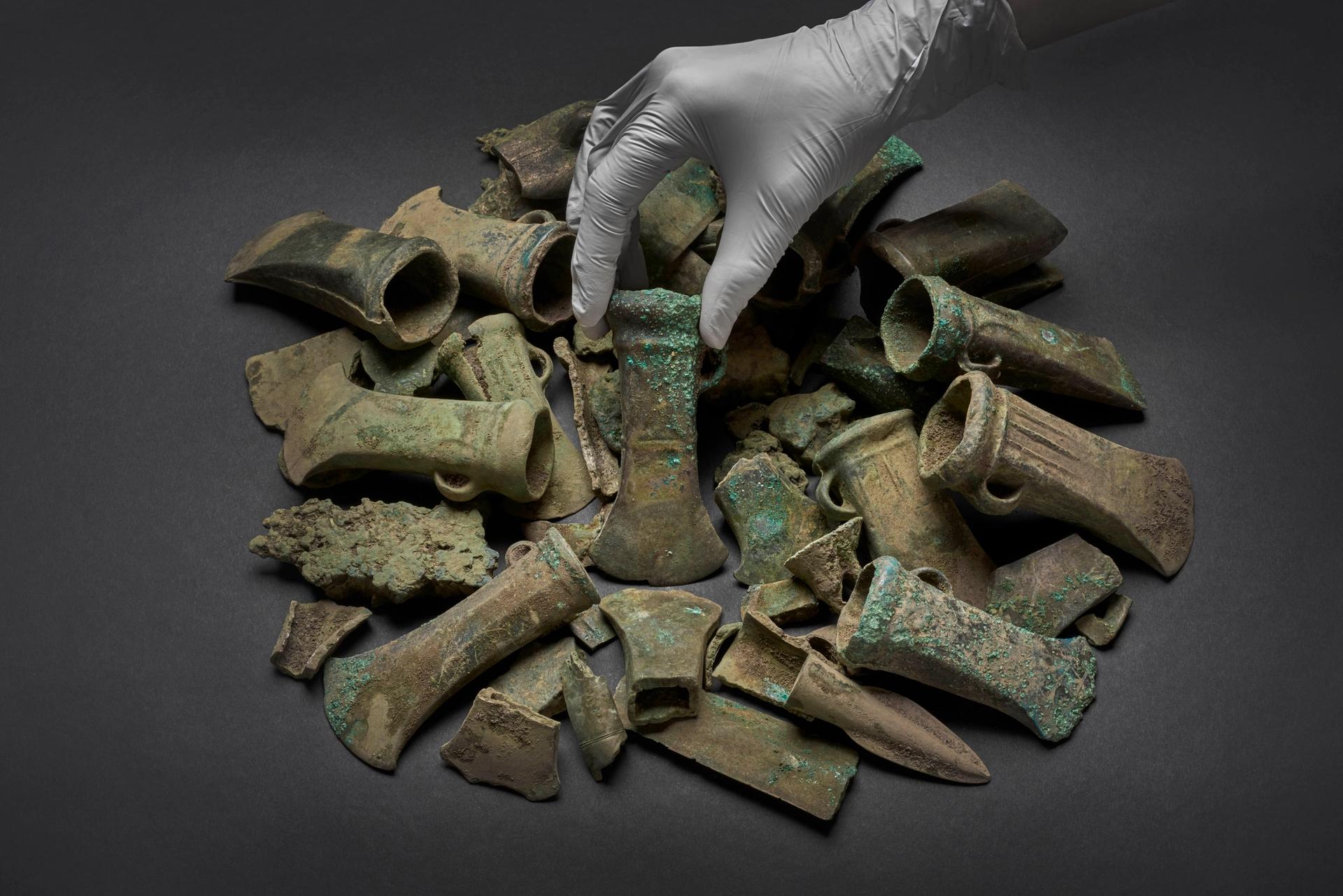 A Bronze Age axe head surrounded by a selection of objects from the Havering Hoard © Museum of London