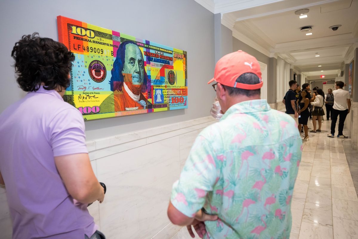 Visitors to the Big Board Art Hall gallery look at a work by Mister E Photo Credit: NYSE / NYSE Art Show