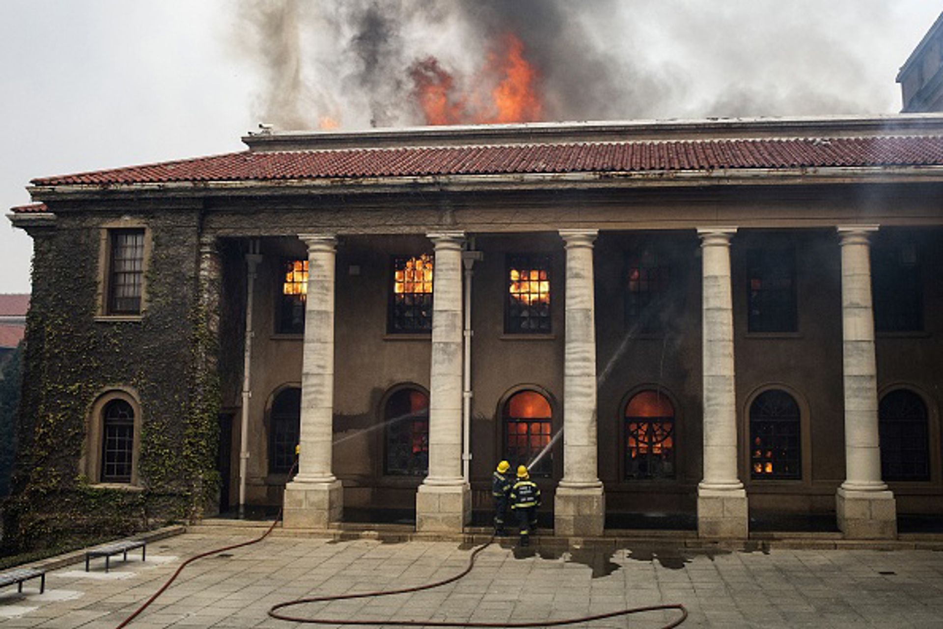 Firefighters try, in vain, to extinguish a fire in the Jagger Library, at the University of Cape Town, after a forest fire came down the foothills of Table Mountain, setting university buildings alight in Cape Town, on 18 April Photo: Rodger Bosch/AFP via Getty Images