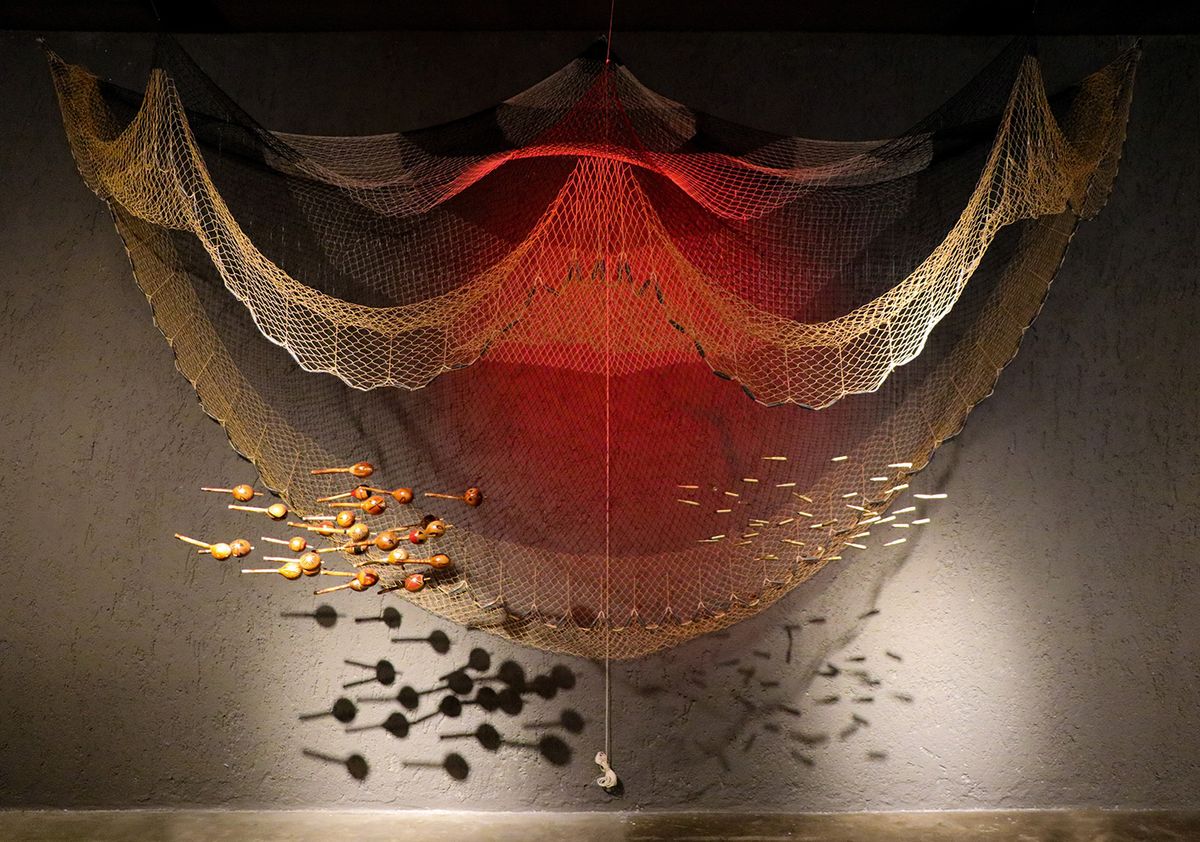 Ziel Karapotó’s Cardume (school of fish, 2023), composed of fishing net, gourd maracas and replicas of fired cartridges Courtesy of the artist