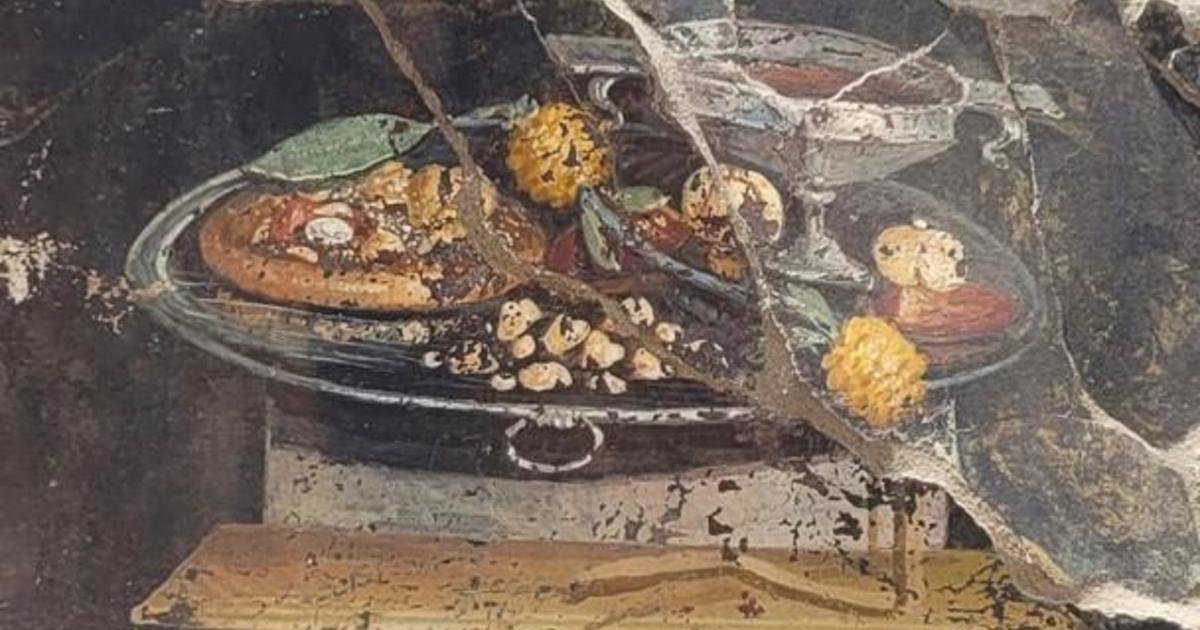 The image is believed to be a pizza predecessor; a focaccia-style bread covered with fruit such as a pomegranate and dates, and a type of pesto
Courtesy Archaeological Park of Pompeii