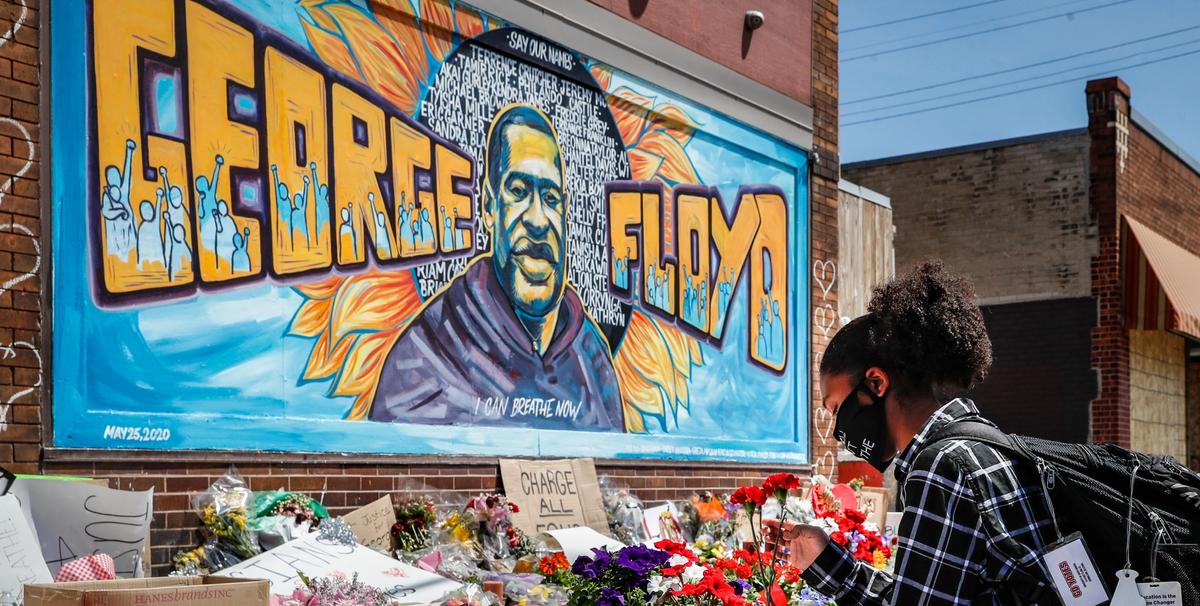 Malaysia Hammond, 19, places flowers at a memorial mural for George Floyd at the corner of Chicago Avenue and 38th Street, Sunday, May 31, 2020, in Minneapolis. Protests continued following the death of George Floyd, who died after being restrained by Minneapolis police officers on Memorial Day AP Photo/John Minchillo