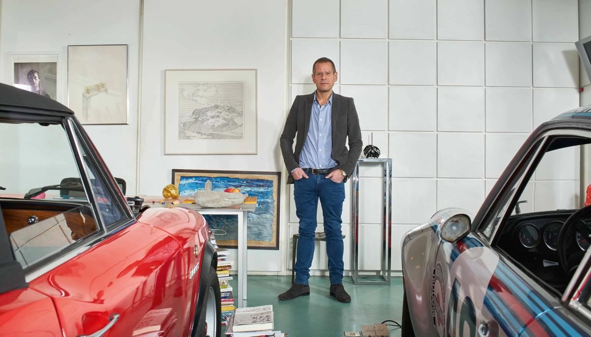 Kenny Schachter, caught in a rare moment not wearing tracksuit bottoms, in his office, surrounded by his collection and, naturally, two cars Courtesy of Sotheby's