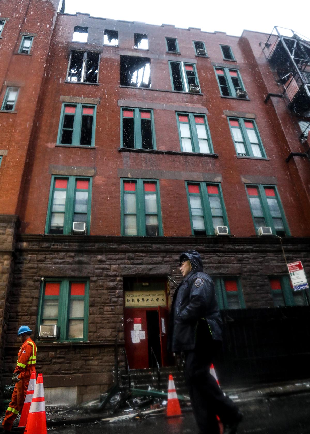 A police officer patrols the scene outside a building that housed the archive of the Museum of Chinese in America, destroyed by fire in New York's Chinatown AP Photo/Bebeto Matthews
