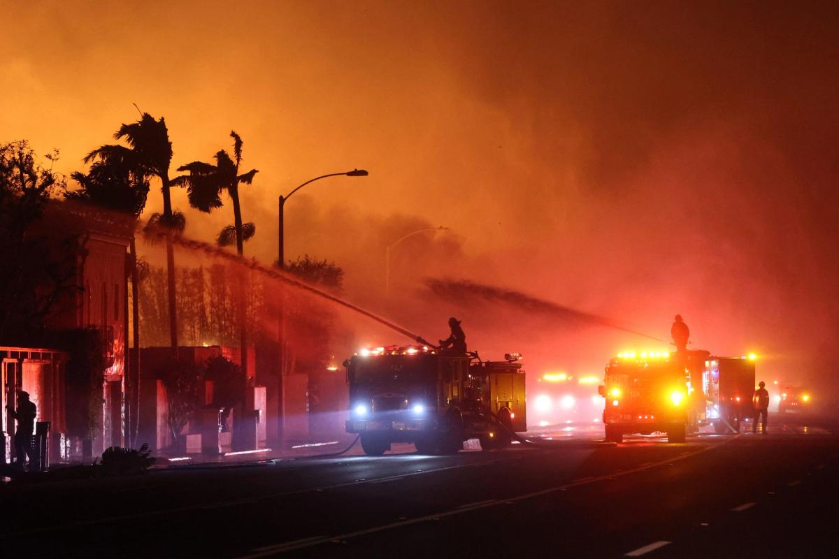 Firefighters spray water on burning structures to contain the rapid spread of the Palisades fire in Los Angeles on 8 January 2025

Photo: Wildfire Image / Alamy Stock Photo