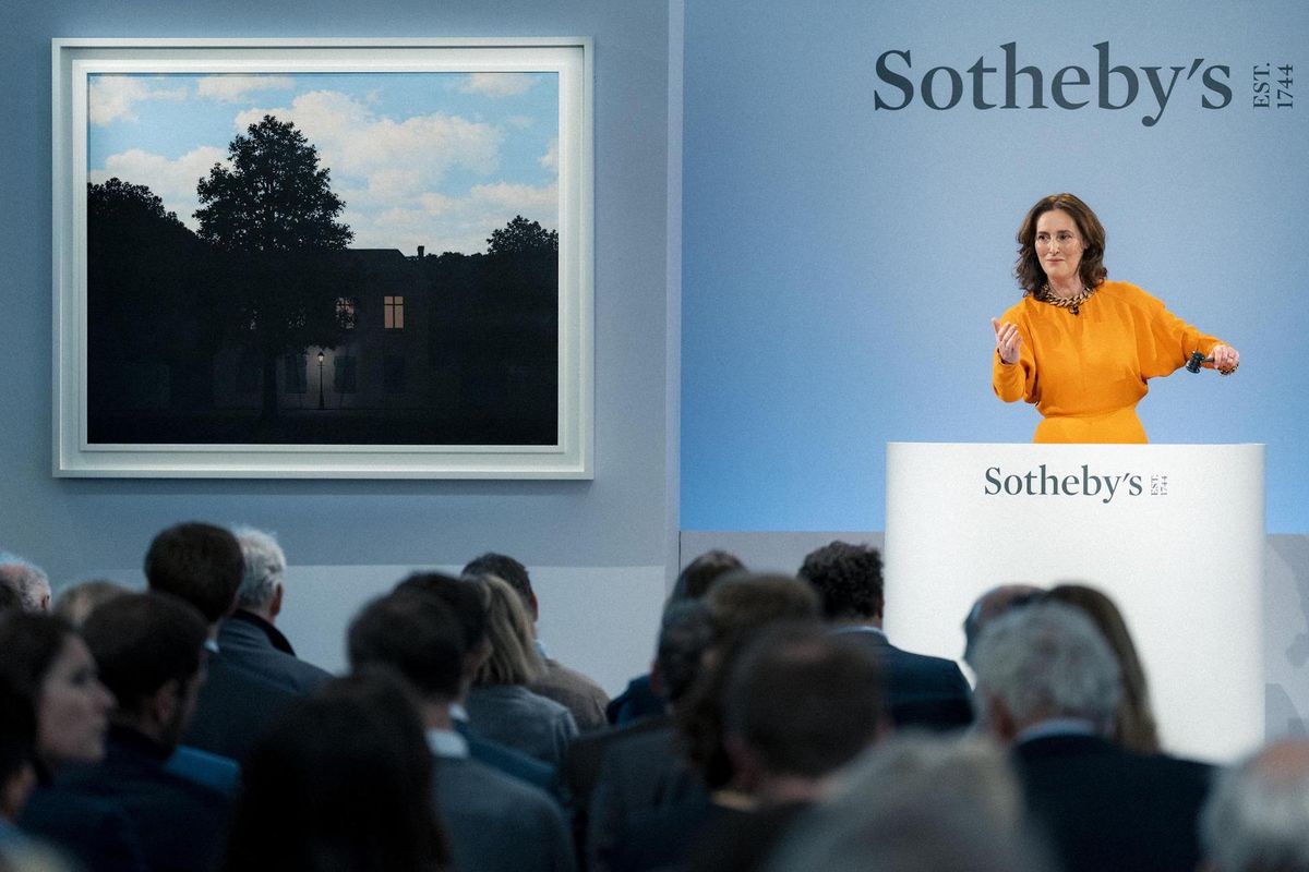 Sotheby's auctioneer Helena Newman alongside René Magritte's 1961 Empire des lumières Courtesy Sotheby's