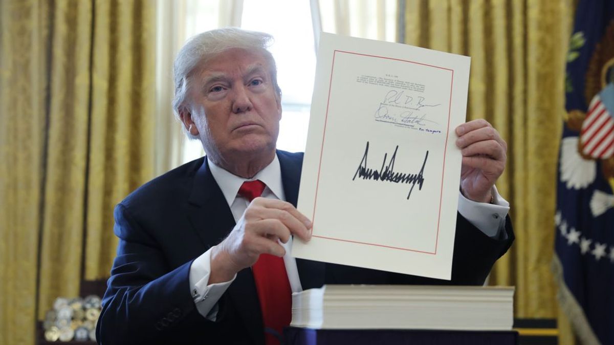 Donald Trump shows his signature on his Act to overhaul taxes Reuters/Jonathan Erns