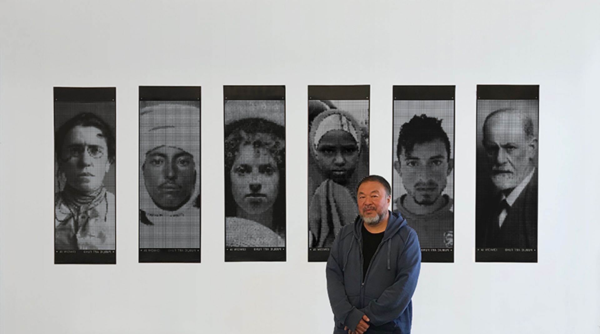 Ai Weiwei in front of his series of limited edition banners to mark World Refugee Day courtesy of eBay and Public Art Fund