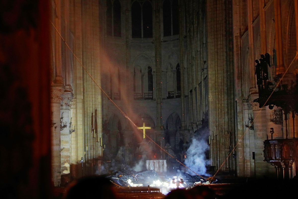 Smoke rising around the altar in front of the cross inside the burning Notre Dame Cathedral on 16 April © REUTERS/Philippe Wojazer/Pool