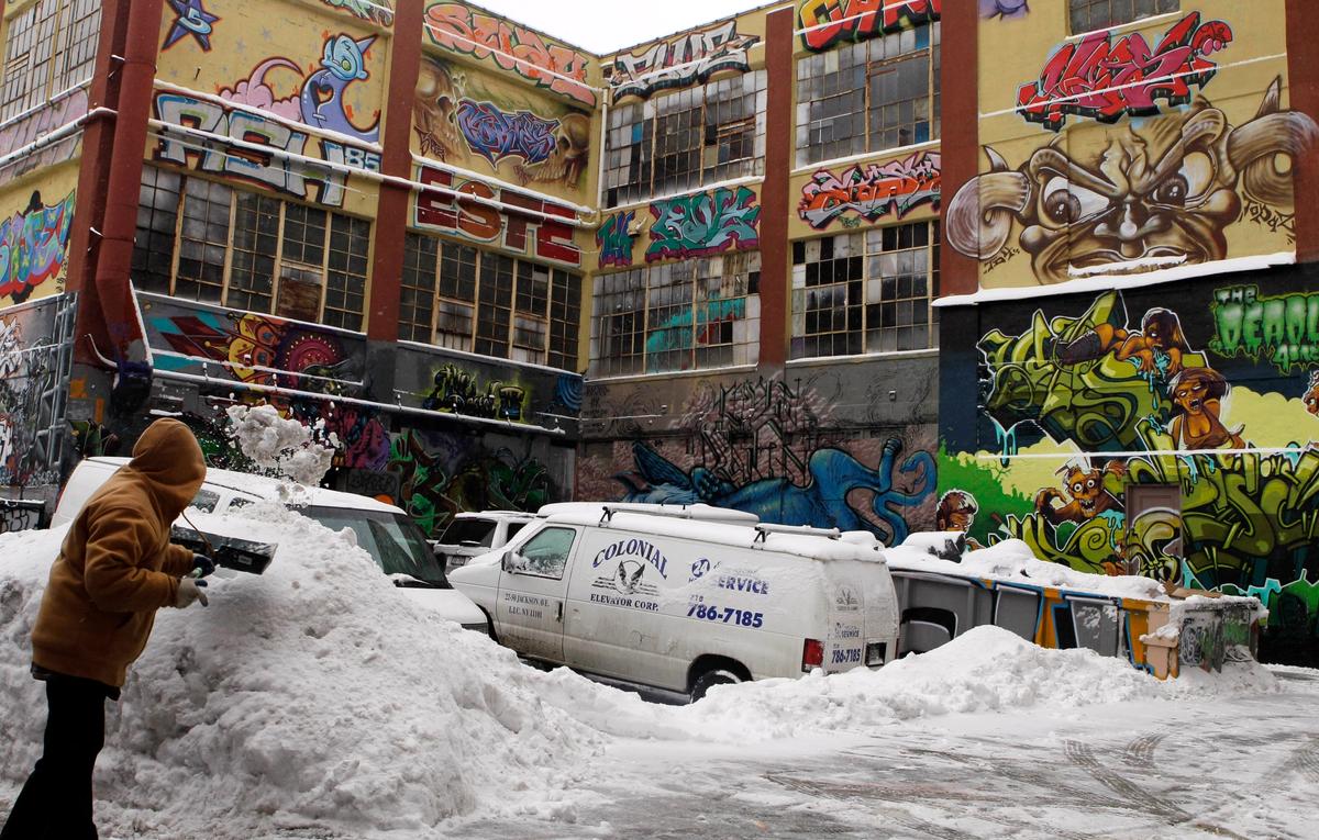 A man shovels snow to clear a driveway near the 5pointz street art complex before it was demolished AP Photo/Frank Franklin II