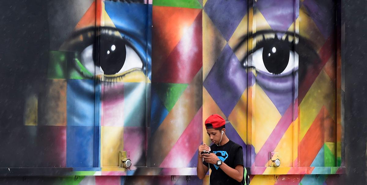 An unidentified man walks in front of a mural by Brazilian artist Kobra in the Wynwood neighborhood in Miami, Florida, on September 28, 2016. Rhone Wise/AFP/Getty Images