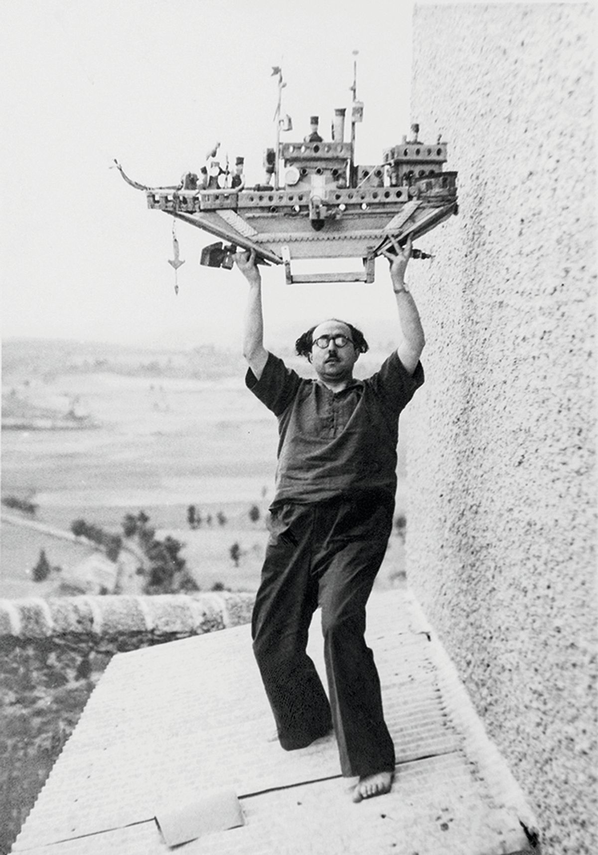 The psychiatrist Francesc Tosquelles, photographed in 1947 by Romain Vigourouxon the roof of the Saint-Alban psychiatric hospital, holding a sculpture created by Auguste Forestier © Roberto Ruiz
