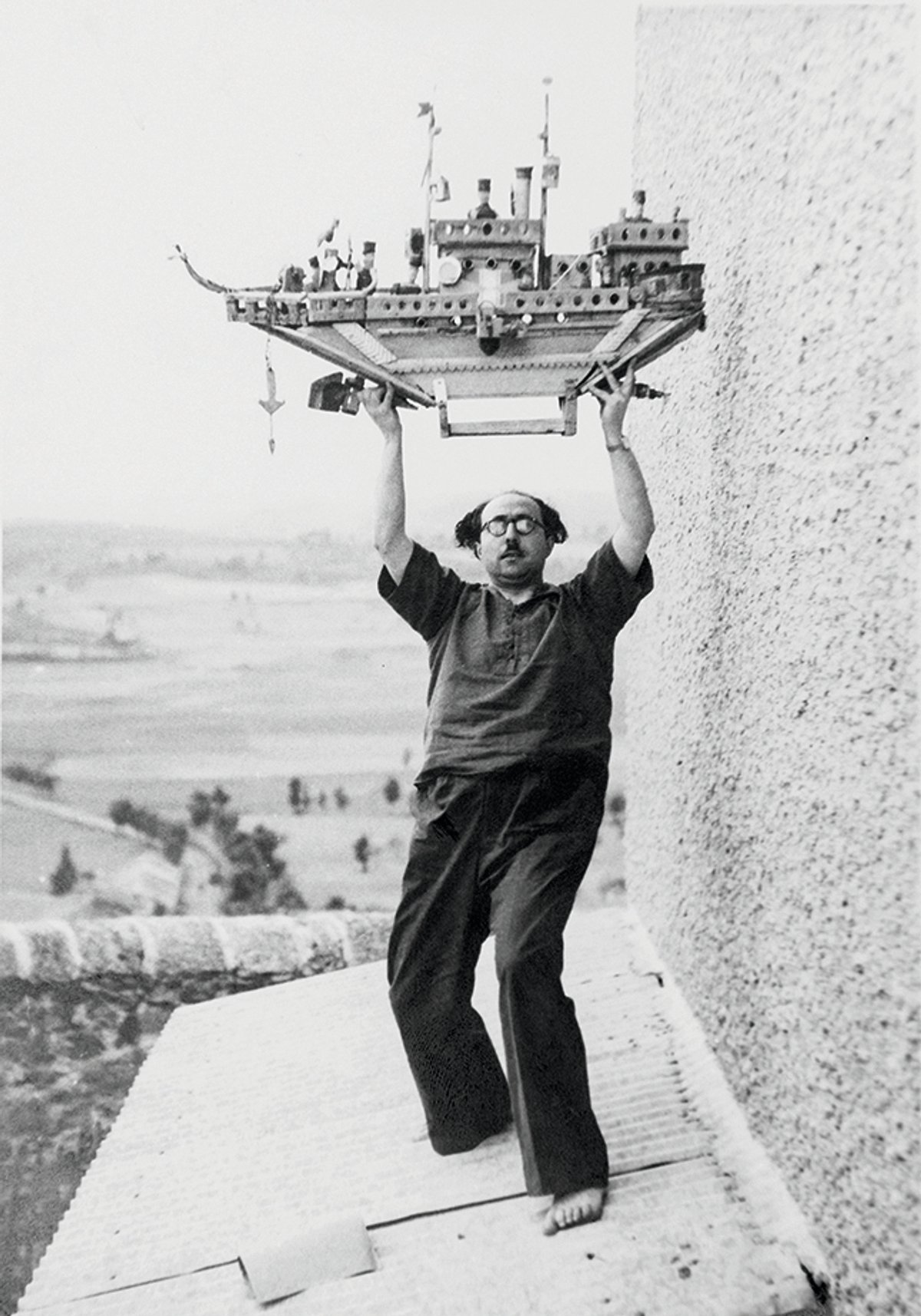 The psychiatrist Francesc Tosquelles, photographed in 1947 by Romain Vigourouxon the roof of the Saint-Alban psychiatric hospital, holding a sculpture created by Auguste Forestier © Roberto Ruiz