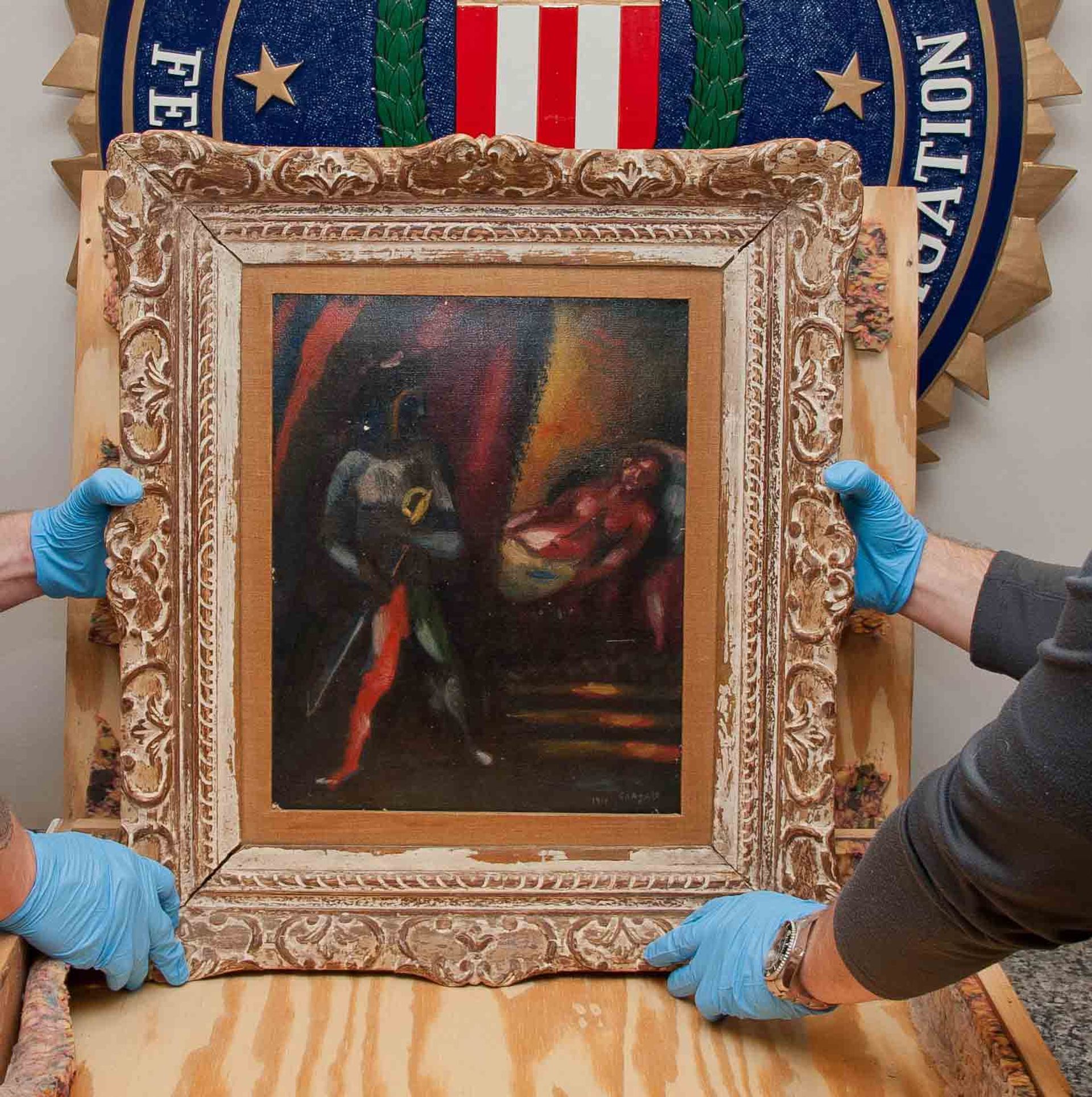Members of the FBI's Art Crime Team holding a recovered work by Marc Chagall, Othello and Desdemona (1911) FBI