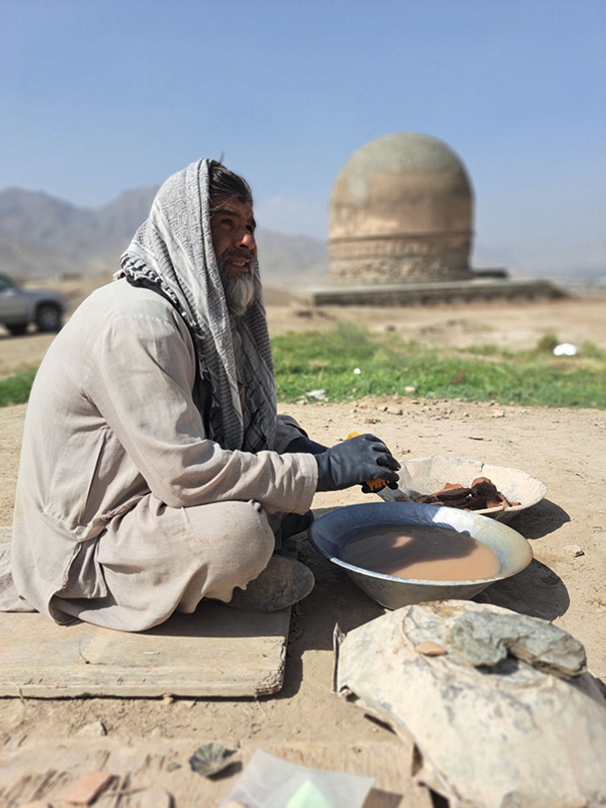 A local man in Shewaki cleans archaeological findings in front of the stupa, which is around 1,500 years old
Photo: Sarvy Geranpayeh