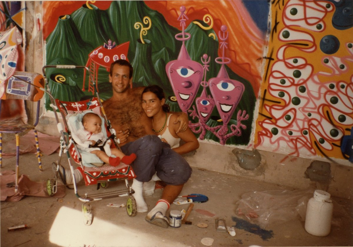 Kenny Scharf with his daughter, Zena, and wife, Tereza, in 1984, posing in front of Scharf’s artwork in Bahia, Brazil as seen in Kenny Scharf: When Worlds Collide, directed by Malia Scharf and Max Basch. A Greenwich Entertainment release Photo: Oliver Sanchez