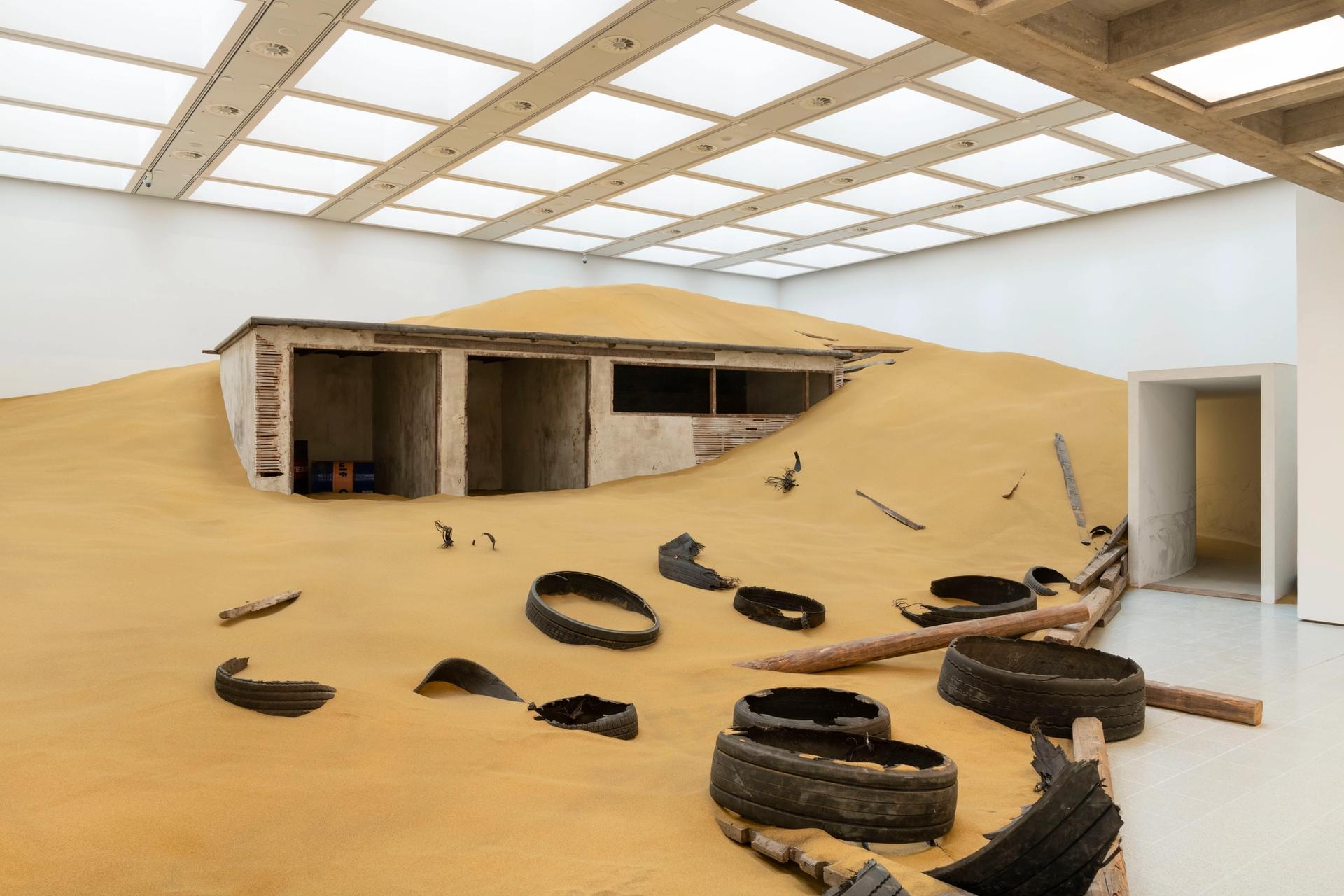 Installation view of Mike Nelson's Triple Bluff Canyon (the woodshed), (2004), and M25, (2023). 

Photo: Matt Greenwood. Courtesy the artist and the Hayward Gallery