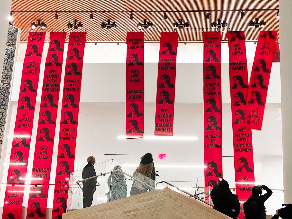 Banners featuring images and slogans in support of the Iranian uprisings are unfurled at SFMOMA