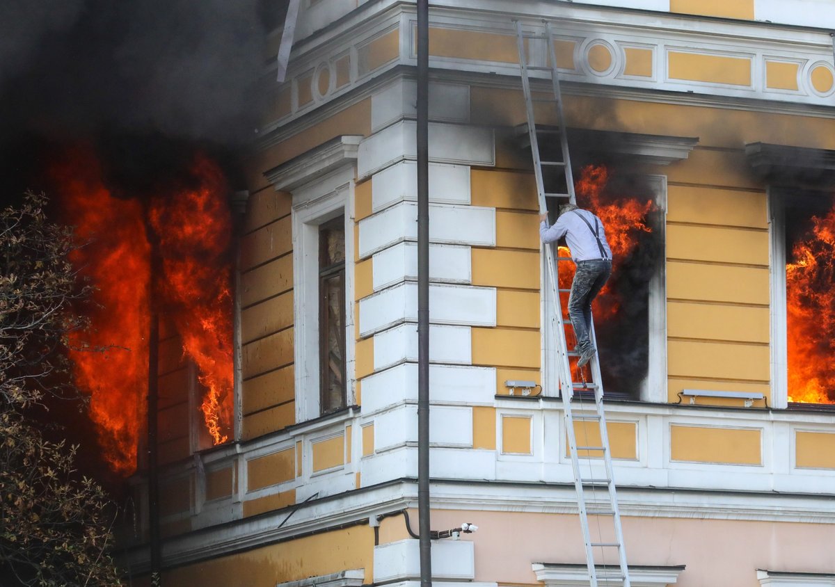 A man flees a burning section of the Academy of Sciences on 28 September following the attack
Photo: Volodymyr Tarasov via Reuters Connect