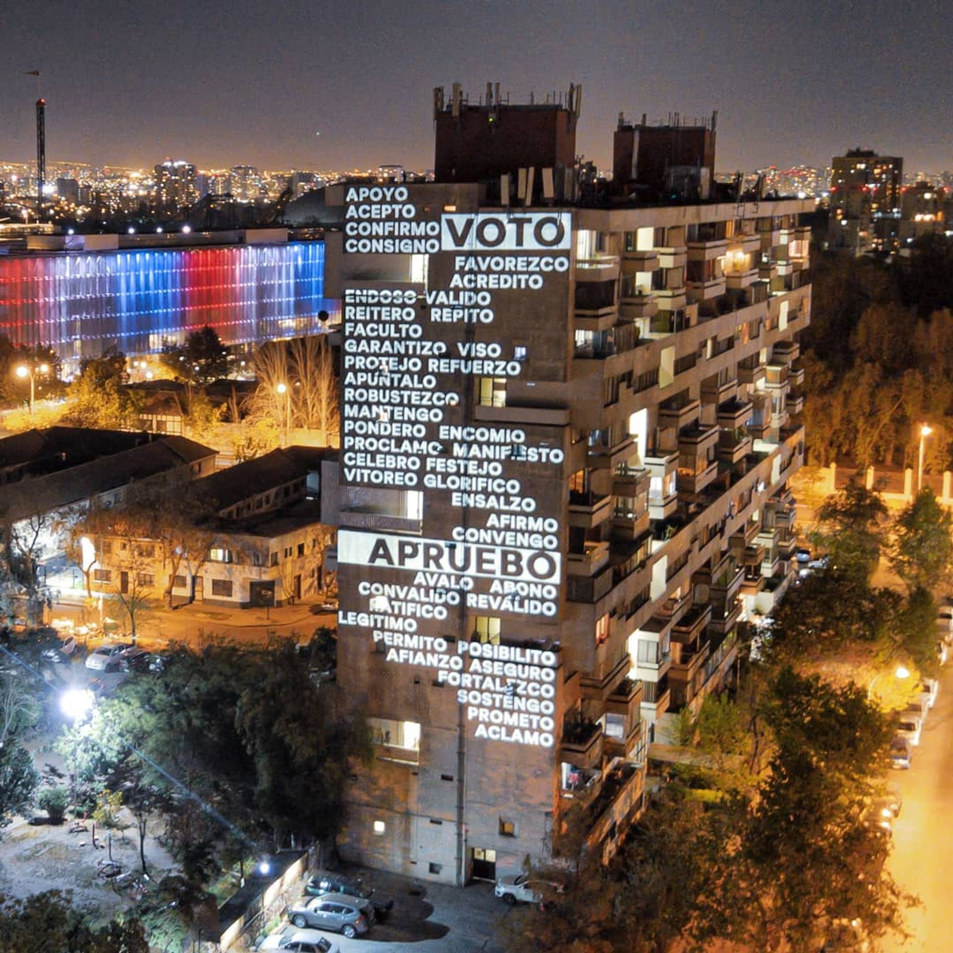 An "artivism" intervention by the Chilean design duo Delight Lab, projected on the side of one of Santiago's landmark Modernist Remodelación República apartment buildings, urges citizens to vote for a new constitution Photo: @delight_lab_oficial on Instagram