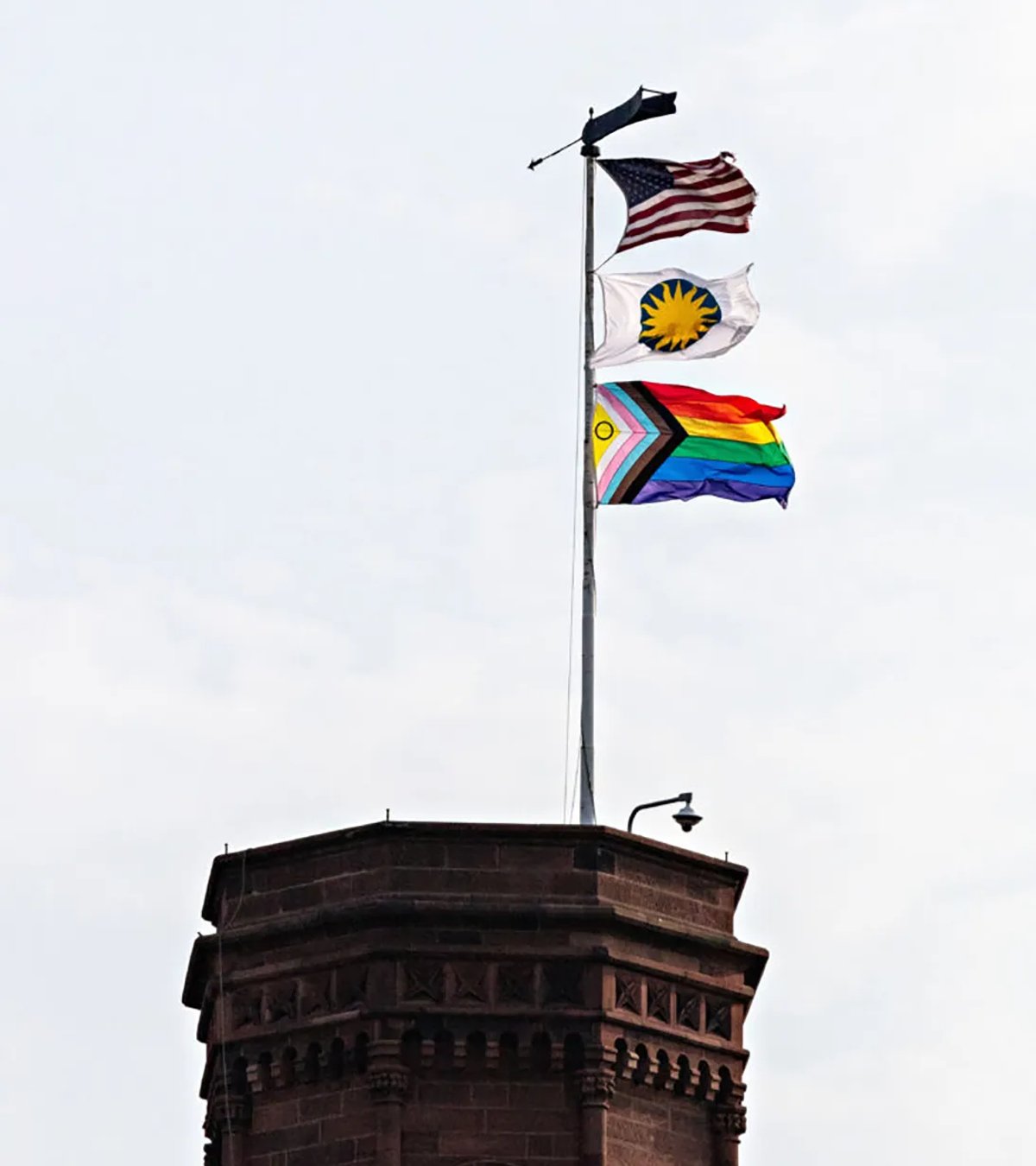 This image of three flags (US, Smithsonian Institution, and Intersex-Inclusive Progress Pride) atop the Smithsonian Castle in Washington, DC, was used as an example of recent objectionable moves in the White House‘s list Courtesy the Smithsonian Institution
