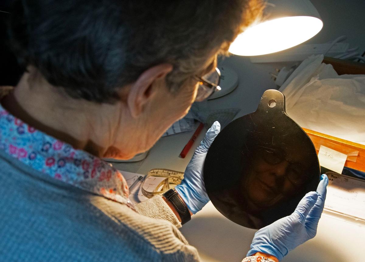 Researcher Elizabeth Healey studying John Dee's obsidian spirit mirror. © S. Campbell