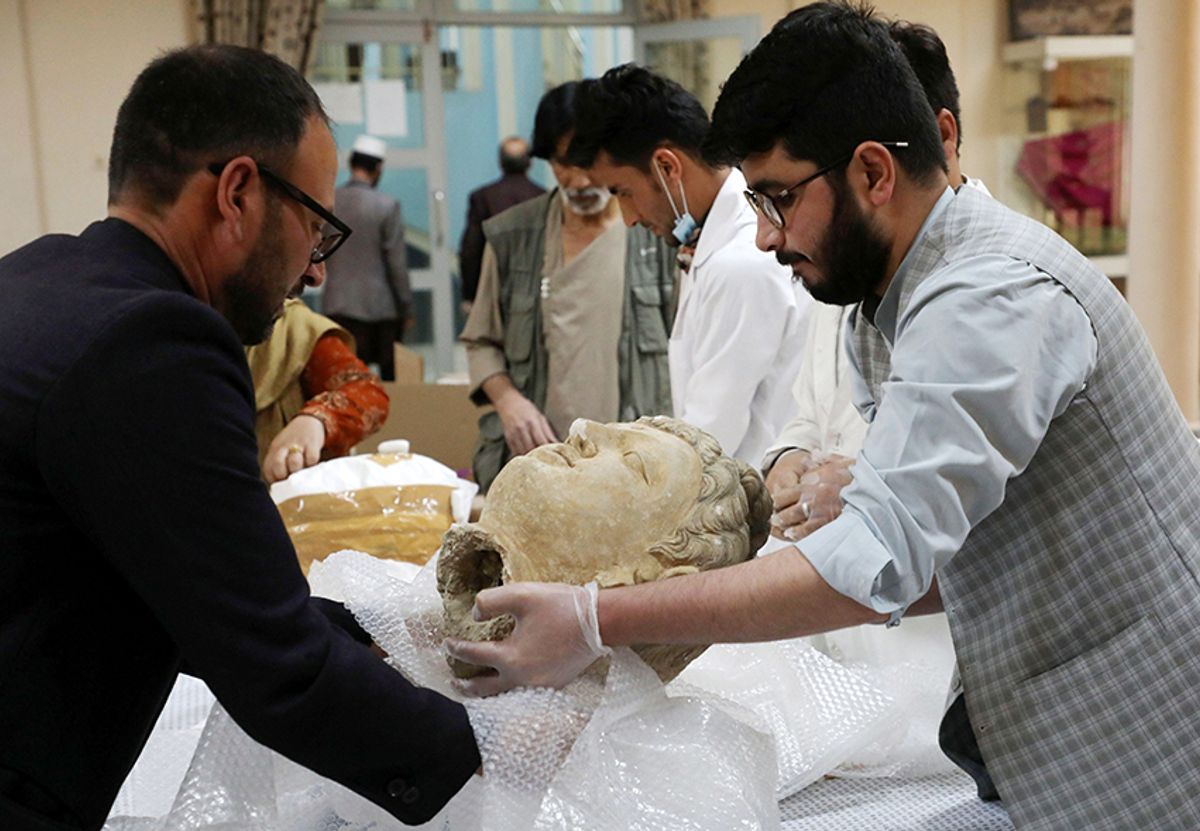 Museum workers unpack an artefact that was smuggled to the US during the wars and was only just returned to the Afghan National Museum in Kabul, Afghanistan, on 29 April 2021 © Reuters / Alamy Stock Photo
