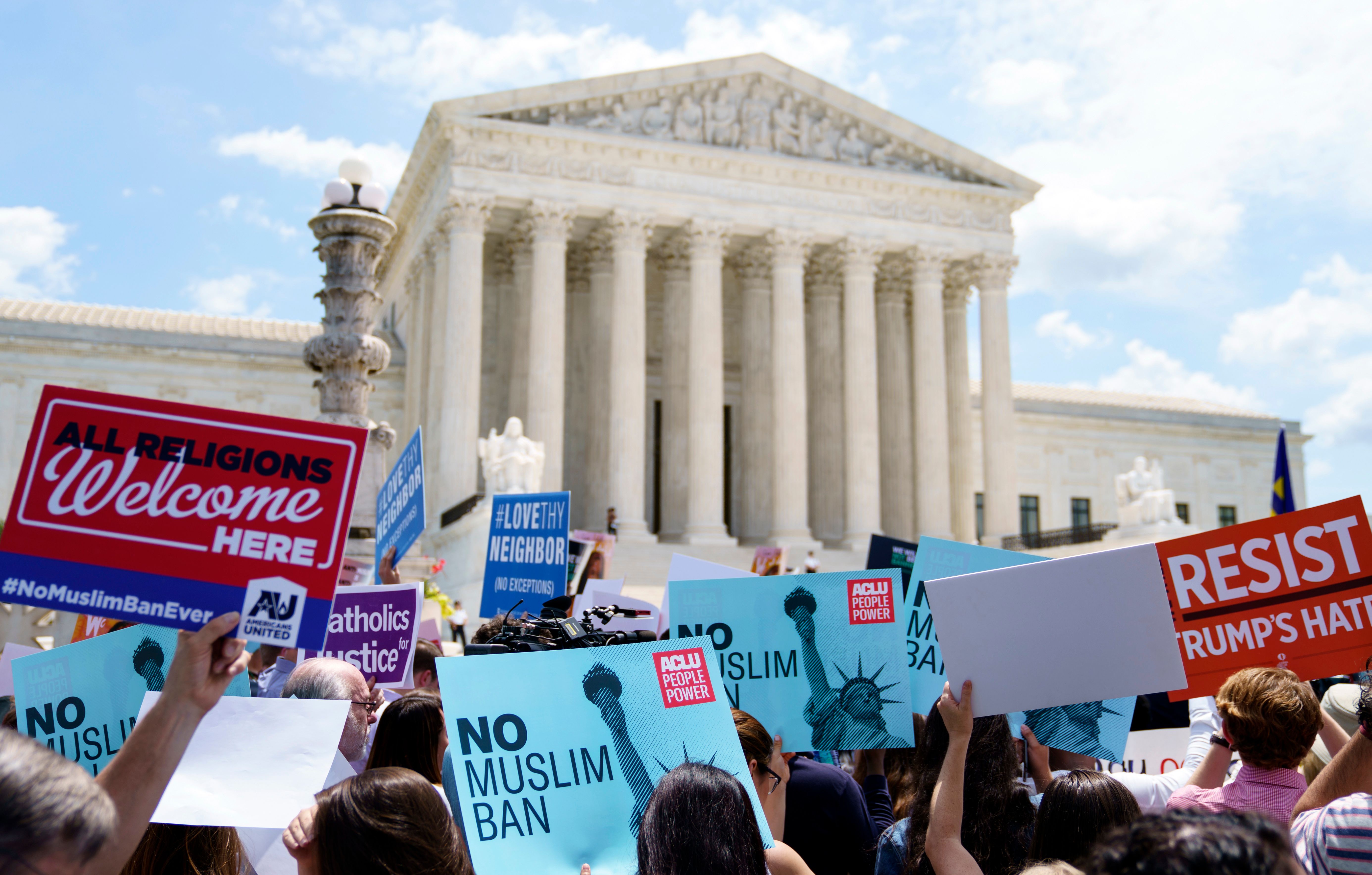 Protesters hold up signs and call out against the Supreme Court's ruling upholding President Donald Trump's travel ban outside the court in Washington, DC on Tuesday AP Photo/Carolyn Kaster