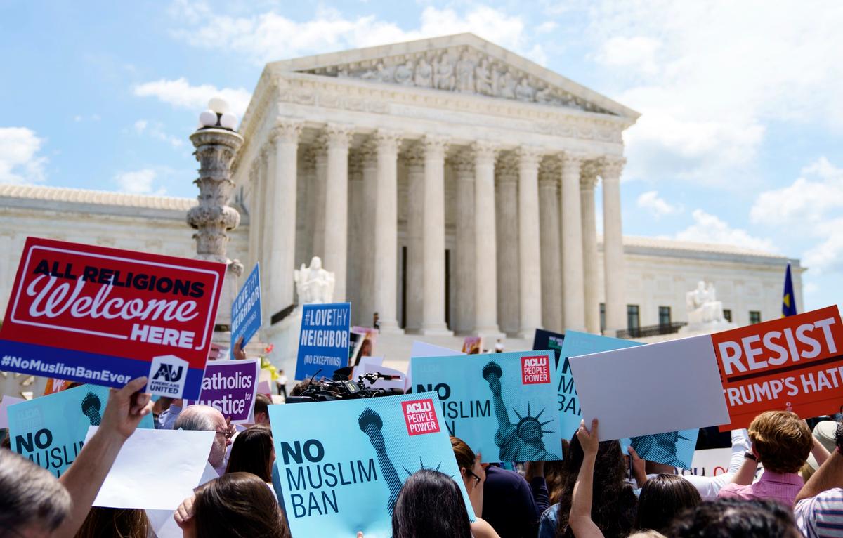 Protesters hold up signs and call out against the Supreme Court's ruling upholding President Donald Trump's travel ban outside the court in Washington, DC on Tuesday AP Photo/Carolyn Kaster