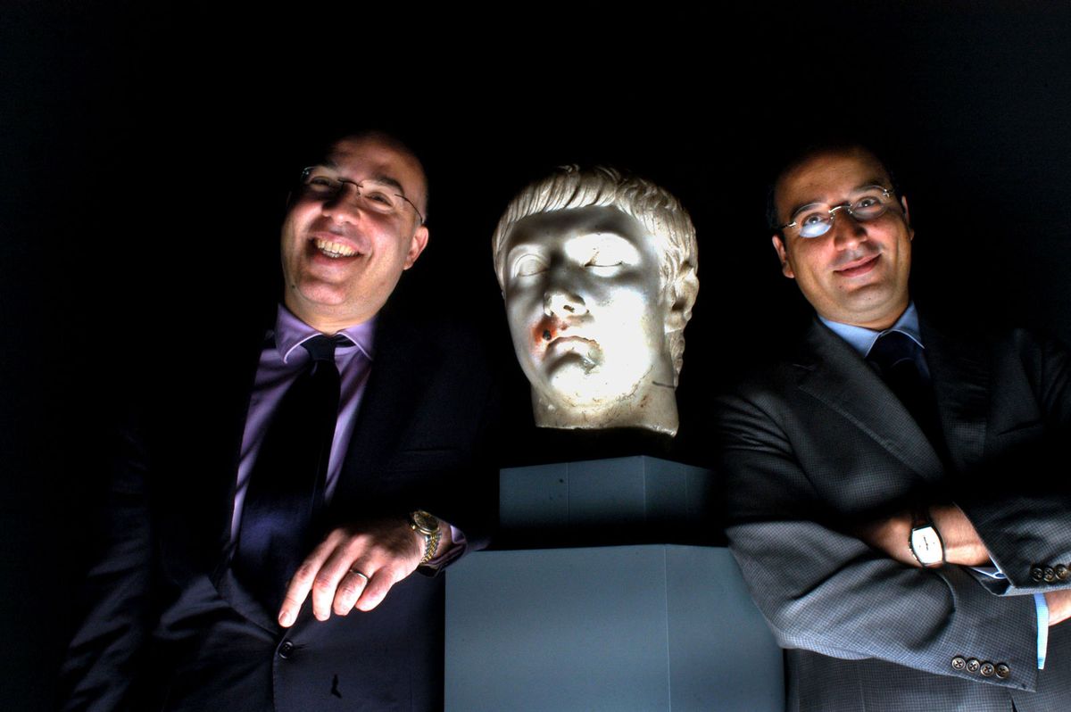 Ali Aboutaam, left, and brother Hicham Aboutaam of the Phoenix Ancient Art Company pose with a monumental marble head of the Emperor Tiberius, which is not believed to be among the seized items © Alastair Miller/Bloomberg via Getty Images