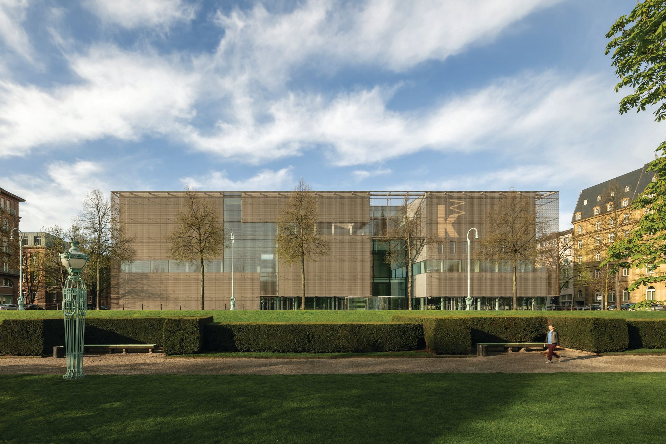 The façade of the new structure is enveloped in a bronze mesh Constantin Meyer