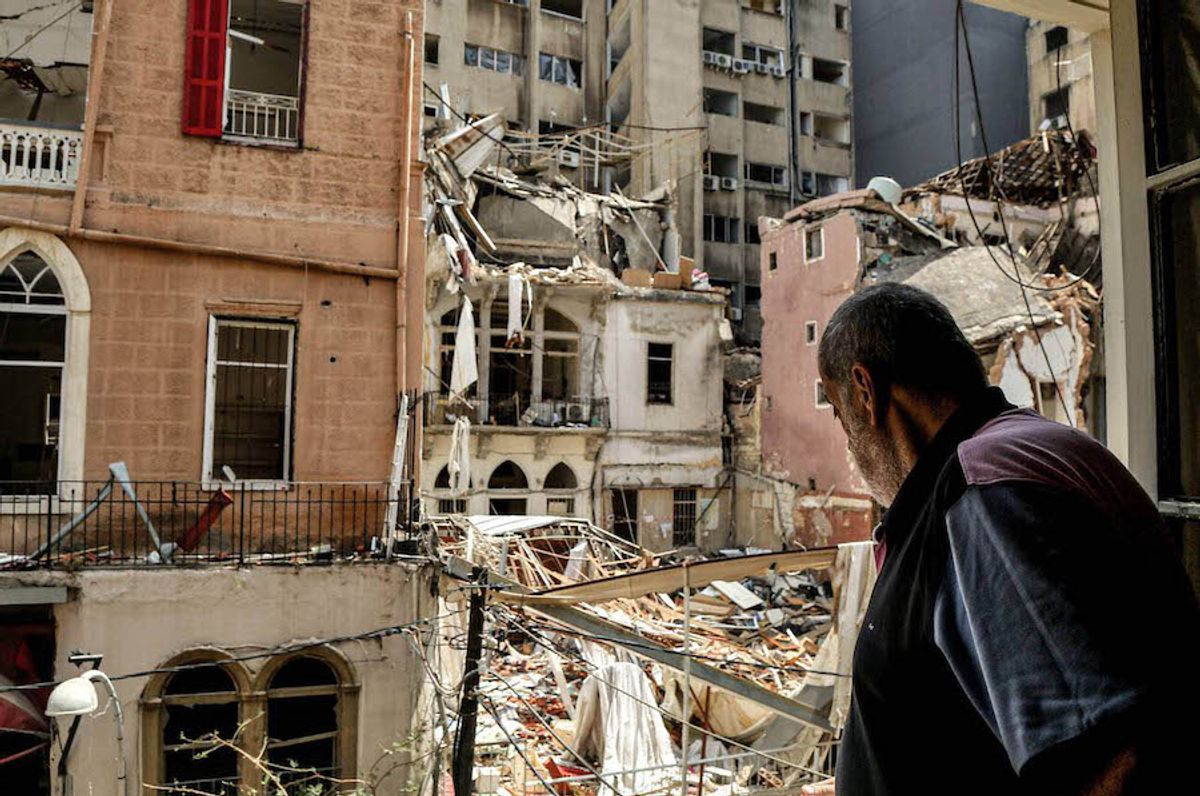 A man stares from a window towards the ruins of a heritage building in the Mar Mikhael neighbourhood, one of several historic districts in Beirut that bore the brunt of the explosion Marwan Naamani/dpa/Alamy Live News