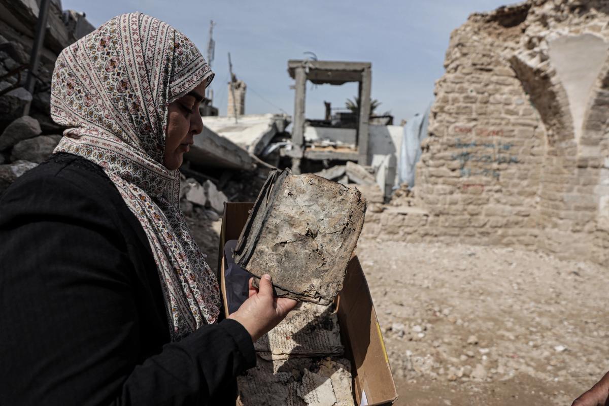 Haneen Al-Amassi with a damaged manuscript rescued from the Great Omari Mosque library Courtesy of Unesco
