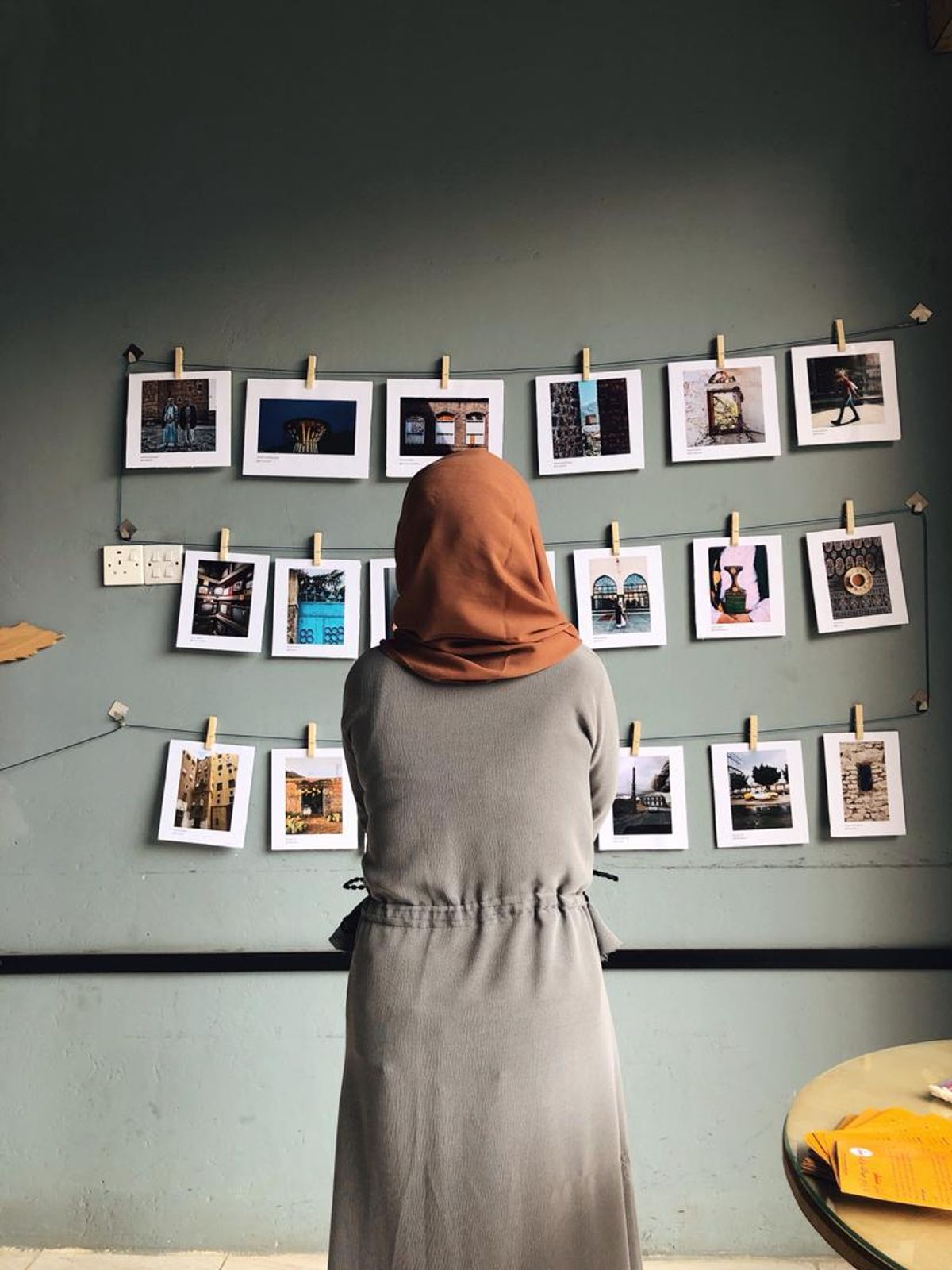 A woman looking at  informal show of "phone art Yemen" in a Sana'a cafe space © Somaya Abdualla