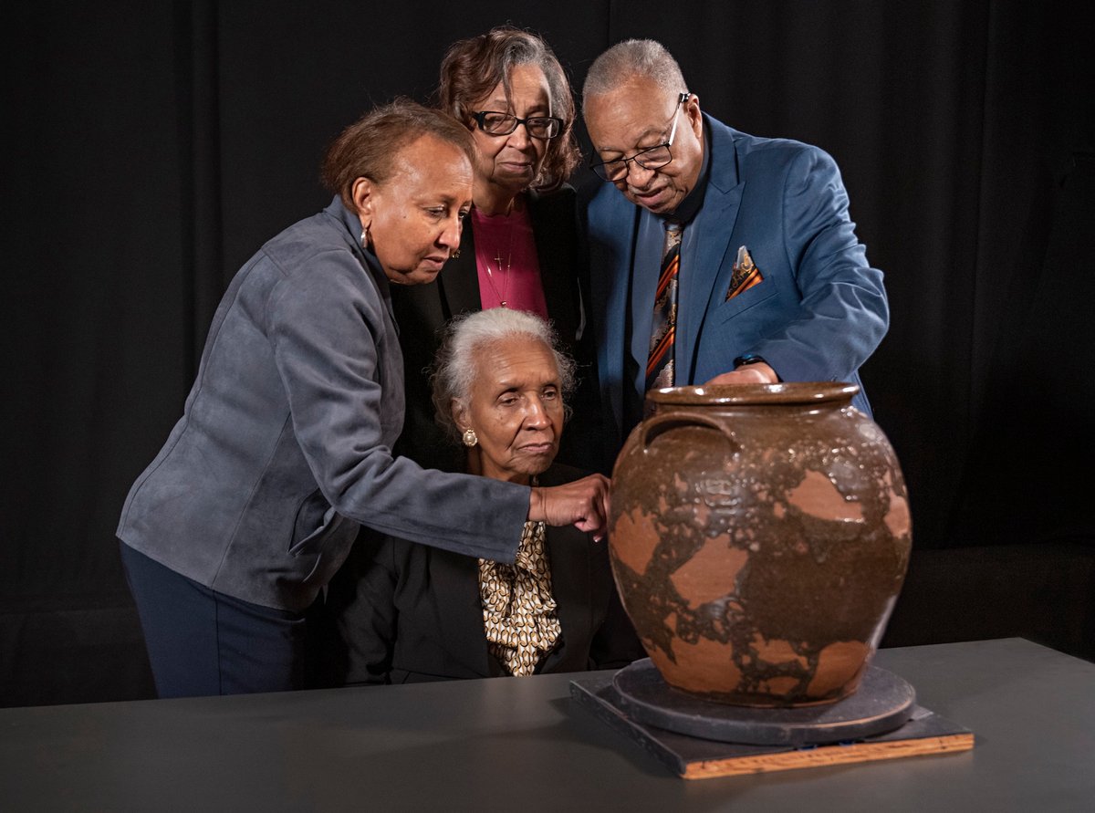 Pauline Baker, Daisy Whitner, John Williams and Priscilla Williams Carolina, descendants of the artist David Drake, at the Museum of Fine Arts, Boston, with one of the artist’s works, Jar (1857) Artwork: Ethically borrowed from the Dave the Potter Legacy Trust LLC, established for the benefit of the artist's descendants. Photo: © Museum of Fine Arts, Boston