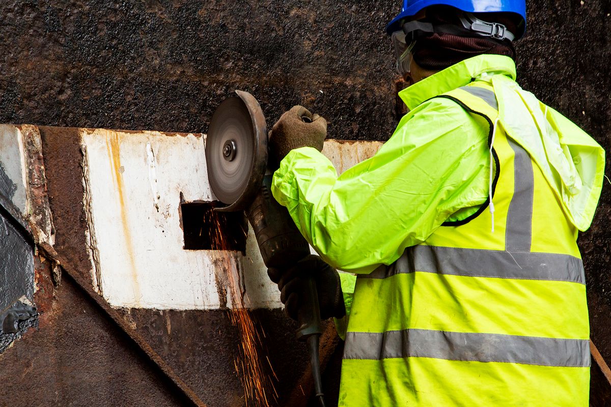 Joe Friel cuts out a metal plate from the old water tanks to be made into a commemorative plaque Goldsmiths, University of London