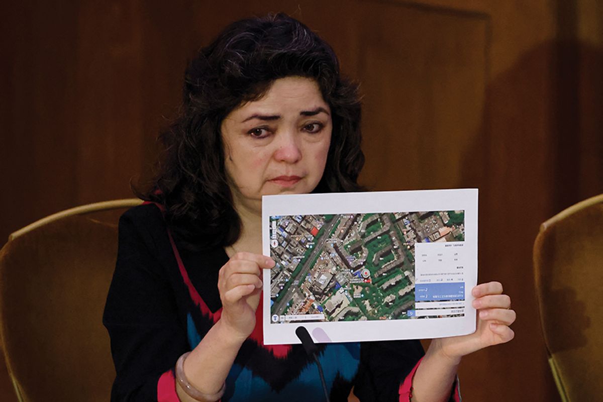 A witness to Uyghur Tribunal holds a photo of the hospital where she says she was forcibly sterilised Photo: Tolga Akmen / AFP