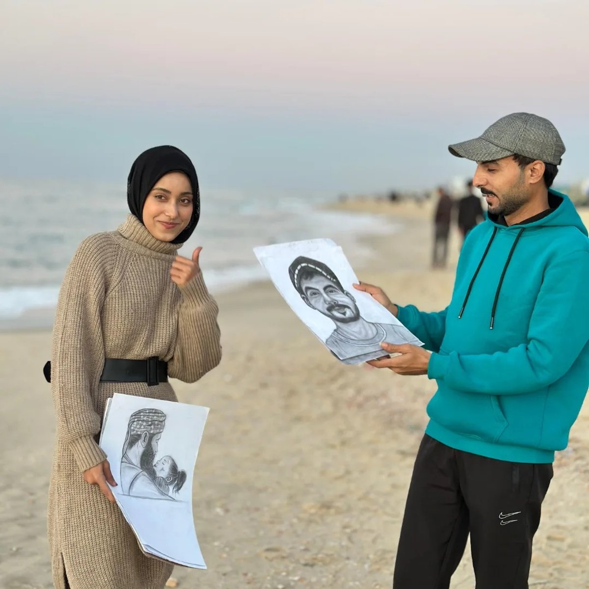 Dina Khaled Zaurub pictured handing her fellow artist Ahmad Abu Al-Roos a portrait she had drawn of him Photo: Dina Khaled Zaurub (Facebook)