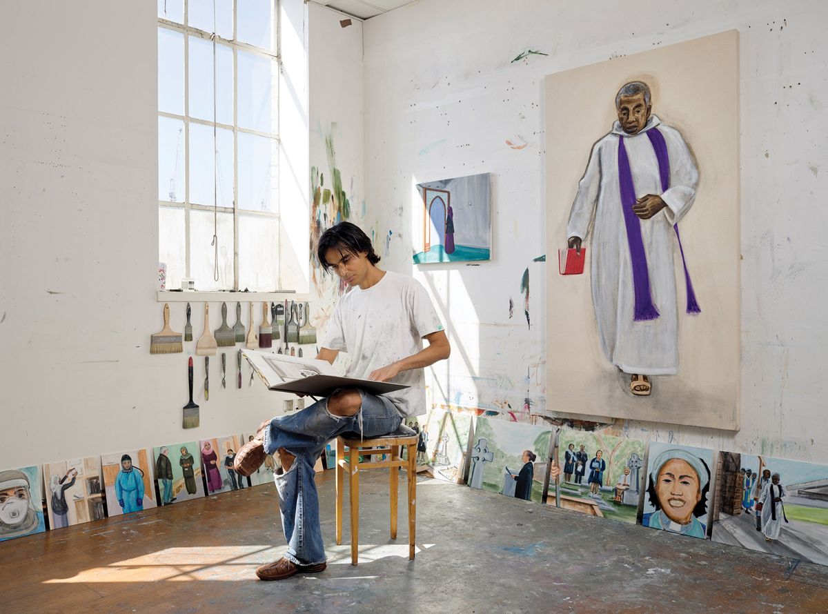 Matthew Krishanu surrounded by his paintings for the Religious Workers series, featuring close personal associates of the artist pictured at work during the pandemic Photo: Peter Mallet