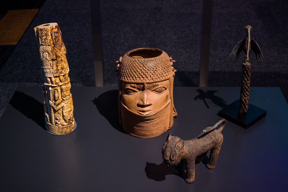 A group of Benin Bronzes on display in the Wereldmuseum. The objects are (from left to rigth): a worked elephant tusk, Benin (1500-1891); a head of a prince (oba), Benin (1600-1750); a statue of a leopard, Benin (19th century); and a staff with 'bird of prophecy', Benin (before 1993)
Photo Boudewijn Bollmann