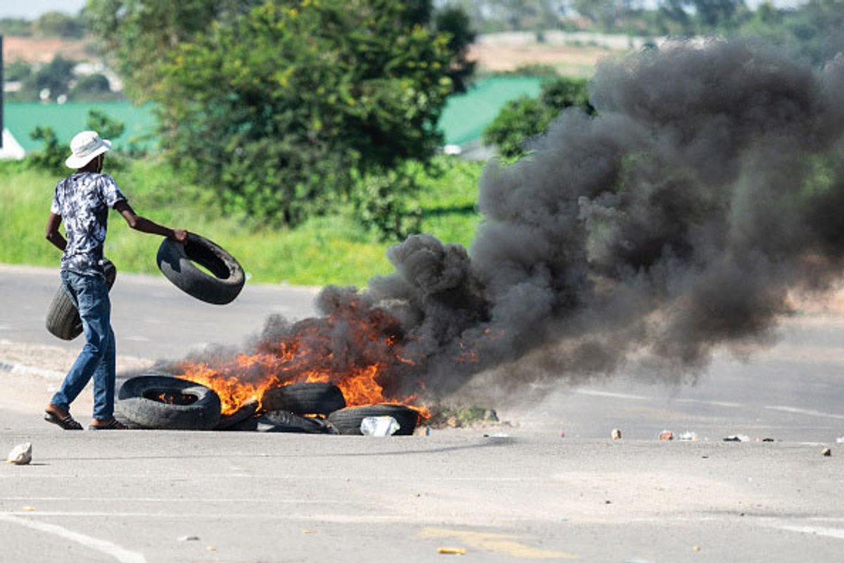 A protesters burns tyres in Bulawayo during a demonstration against the doubling of fuel prices after Zimbabwe's president announced a more than 100% rise in the price of petrol and diesel. © ZINYANGE AUNTONY/AFP/Getty Images