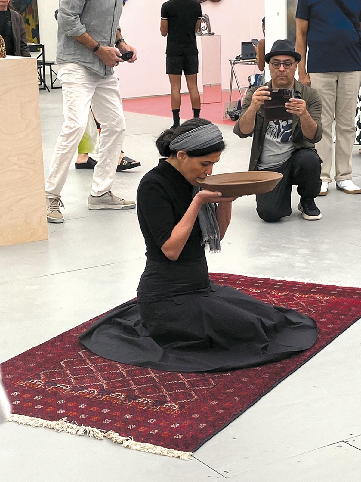 Raheleh Filsoofi bites the edge of a raw clay bowl at Untitled Art fair
Photo by Torey Akers