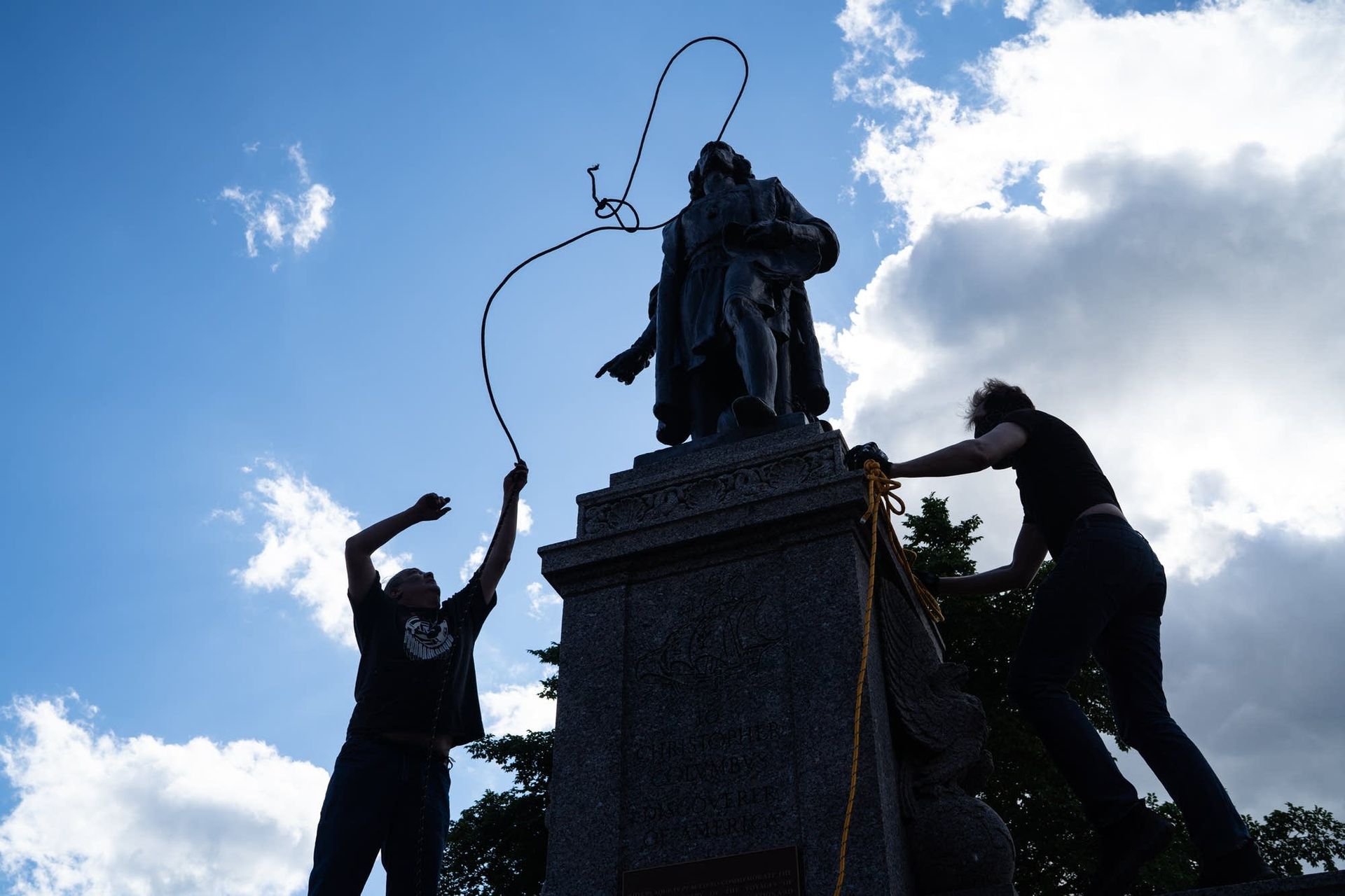 Two men fasten ropes around the neck of a statue of Christopher Columbus at the Minnesota State Capitol in St. Paul on June 10, 2020 Photo: Evan Frost