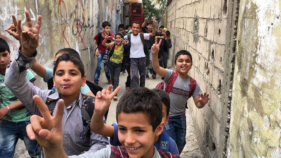 A group of children run through Ain al-Hilweh, the largest Palestinian refugee camp in Lebanon, from Human Flow by Ai Weiwei © Photo courtesy of Amazon Studios