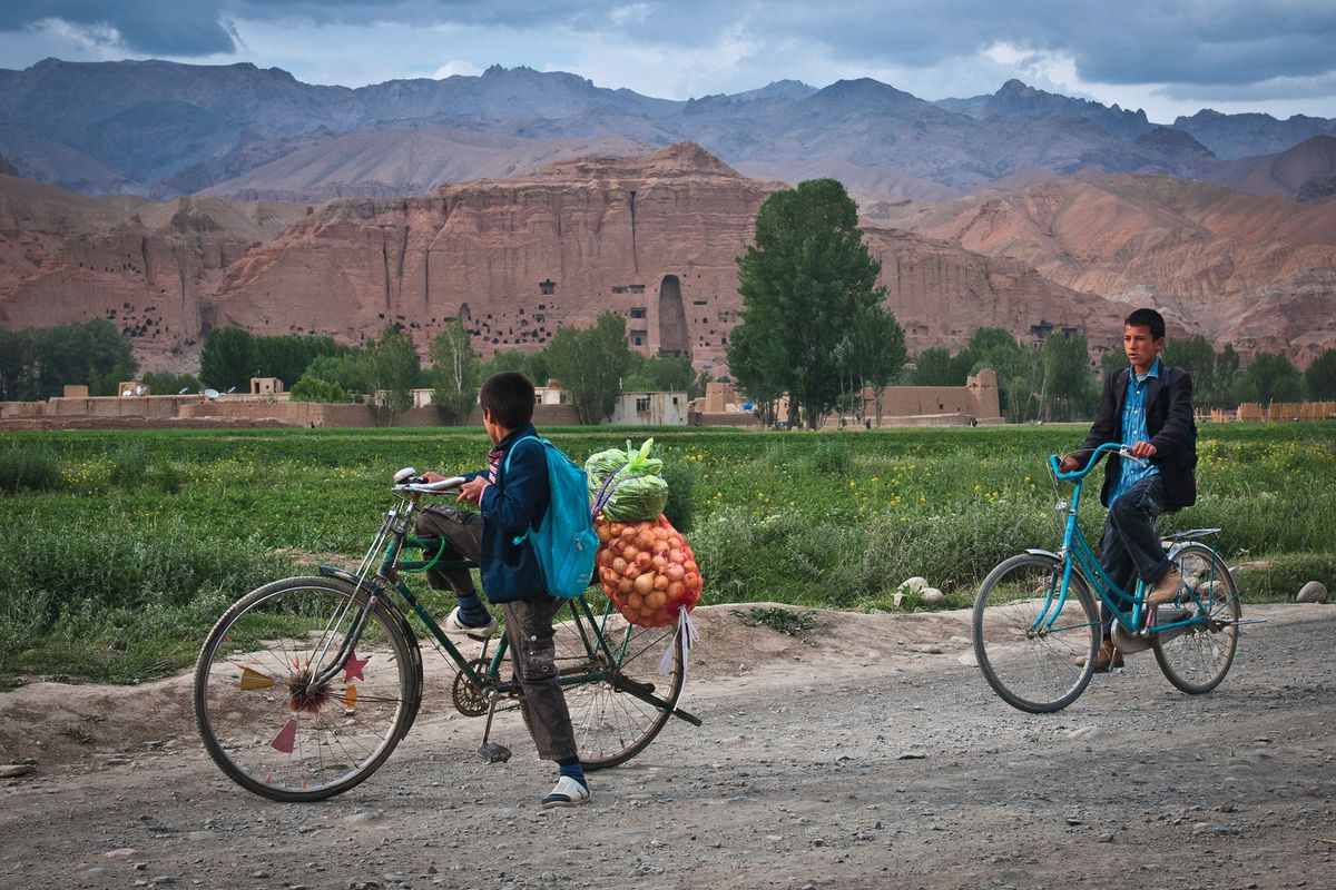 Two boys ride their bicycles past the huge cavity where one of the ancient Buddhas of Bamiyan used to stand. The monumental statues were destroyed by the Taliban in 2001, but the new funding promise brings hope that sites in the Bamiyan valley could be restored

Photo: US Army/Sgt Ken Scar
